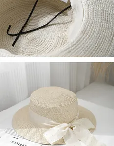 Detail view of beige straw sun hat with beaded ribbon and interior adjustable sizing strap