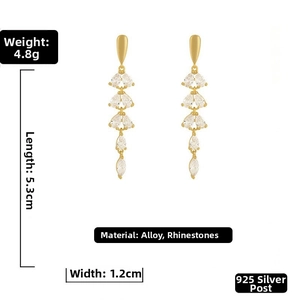 Macro detail of gold tassel earrings with rhinestones and 925 silver needle