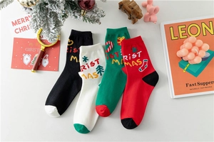 Vue détaillée de chaussettes de Noël festives en coton rouges, vertes, noires et blanches