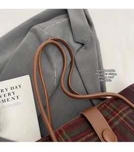 Detailed view of the checkered wool tote bag with comfortable brown shoulder straps