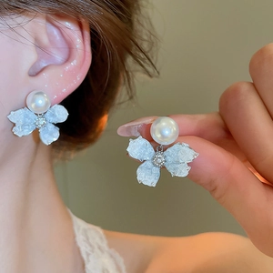 Detailed view of elegant silver needle butterfly earrings with pearl and floral details