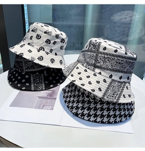 Detailed display of four reversible bucket hats featuring paisley and houndstooth patterns
