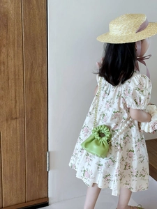 Girl in floral dress with green pleated pearl chain mini handbag and straw hat