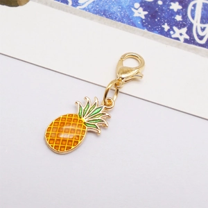 Detail of yellow pineapple enamel charm with gold metal trim and lobster clasp