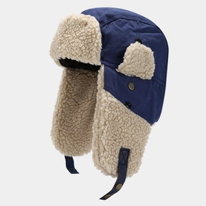 Dettaglio del cappello aviatore in tela blu con spessa fodera in lana beige e paraorecchi