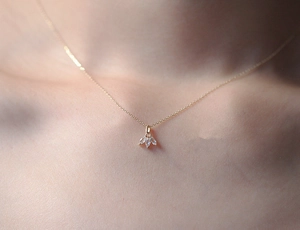 Close-up of elegant gold S925 silver necklace with three marquise diamond leaf pendant