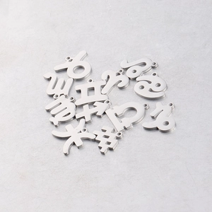 Macro view of 15mm mirror polished stainless steel zodiac pendants with cut-out designs