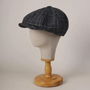 Detail of classic black and white plaid newsboy cap with textured fabric on a mannequin head