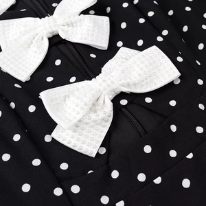 Polka dot mini dress with pearl bow accents and zipper closure on the back