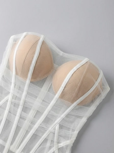 Detail of white mesh bustier dress featuring internal boning and sheer layered fabric