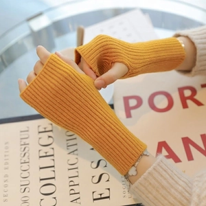 Detail of yellow knitted fingerless gloves with ribbed wrist cuffs for winter warmth
