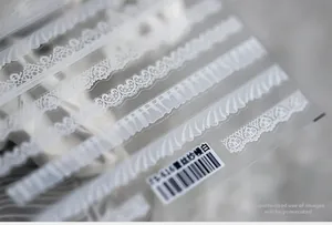Vue macro détaillée des motifs de stickers nail art en dentelle blanche TS-416