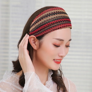 Elegant wide woven headband with red and black geometric patterns on a female model