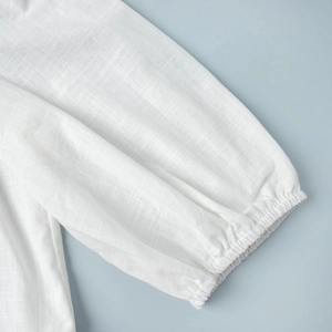 Detailed macro shot of white cotton puff sleeve cuffs with elastic pleated texture