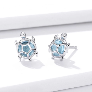 Elegant S925 silver turtle stud earrings with round light blue gemstone on white background