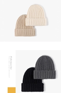 Vertical ribbed knit texture of warm winter beanies in beige, khaki, grey, and black colors