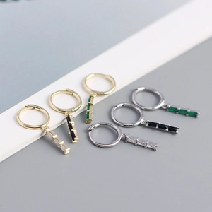 Detailed view of geometric rectangle zircon earrings in gold and silver finishes