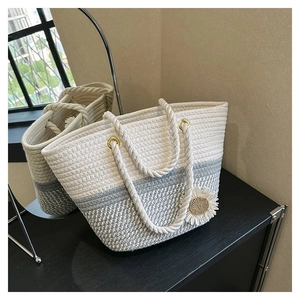 Detail of woven tote bag with daisy pendant showing intricate cotton rope handicraft