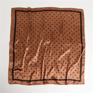 Detailed view of brown satin square scarf with black polka dots showing silky texture