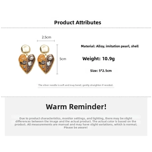 Detail view of heart pearl earrings showing 5x2.5cm size and 10.9g weight specs