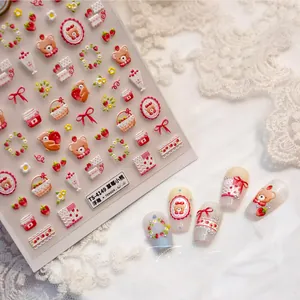 Close-up of strawberry bear embossed nail stickers with intricate floral and 3D textures