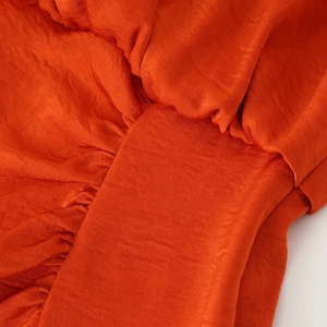 Elegant orange satin sleeveless dress with pleated details and side slit design