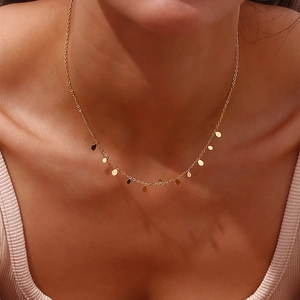 Dettaglio di una collana sottile placcata oro 18K con ciondoli a goccia su modella