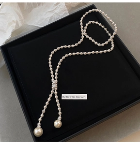 Elegant pearl tassel necklace with zircon charms displayed in a luxury gift box
