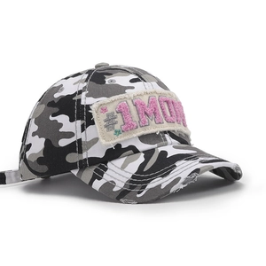 Detailed close-up of camouflage baseball cap with pink #1 MOM embroidery and distressed brim