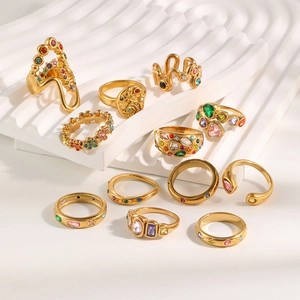 Macro view of multiple gold-plated rings with colorful stones on white background
