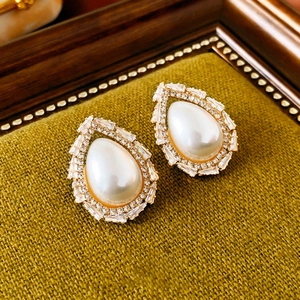 Vue macro de boucles d'oreilles vintage avec perle blanche et cristaux brillants