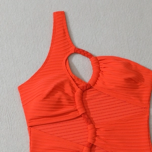 Vue détaillée du tissu côtelé orange fluo et du détail de la bandoulière tressée