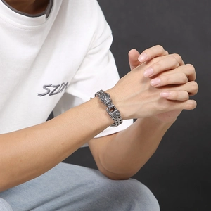Detailed macro view of vintage wolf head stainless steel bracelet on male model
