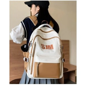 Side view of American vintage white and brown backpack worn by a model in a room