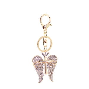 Golden angel wing keychain with crystal crown and cross charm on white background