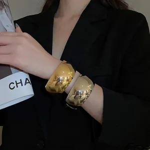 Polished gold geometric oval cuff bracelet with mirror finish for a minimalist modern look