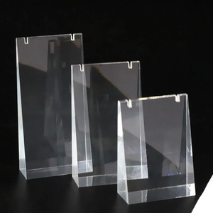 Three-piece clear acrylic jewelry necklace display stands set on a black background
