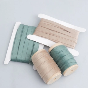 Double-sided velvet ribbon in sage green and champagne beige on wooden spools