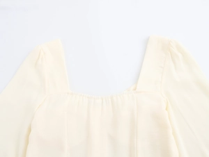 Close-up detail of a beige French square collar dress with puffed sleeves and buttons