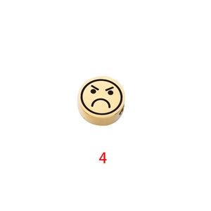 Macro detail of golden stainless steel bead with angry emoji for DIY jewelry