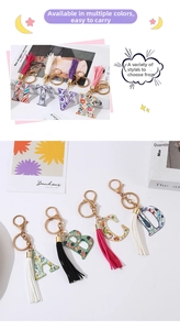 Close-up of floral letter keychain with gold lobster clasp and long silk tassel