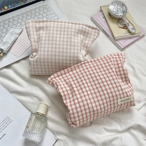 Floral and checkered cotton toiletry bags shown with lifestyle accessories on a desk
