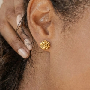 Elegant 18k gold plated stainless steel rose flower stud earrings on female model