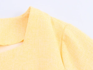 Vista macro dettagliata della trama del tessuto in tweed giallo della giacca da donna