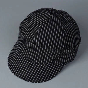 Close-up of black and white vertical striped cadet cap with metal logo detail