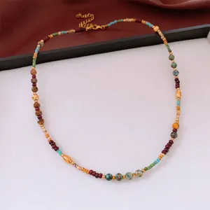 Vintage bohemian beaded necklace with turquoise stones and a golden heart charm pendant