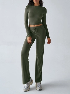 Detail of slim fit long sleeve crop top and matching dark green joggers in Y2K style