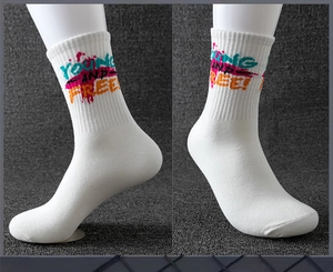 Detail of white cotton athletic socks featuring colorful graffiti Young and Free text