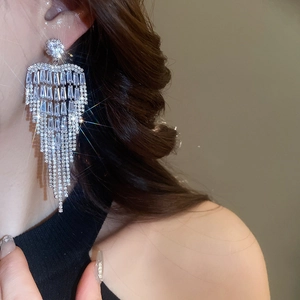 Close-up of sparkling flower tassel earrings with zircons on a model side profile