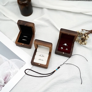 Trois écrins à bagues en noyer avec doublure en velours noir blanc et rouge sur tissu